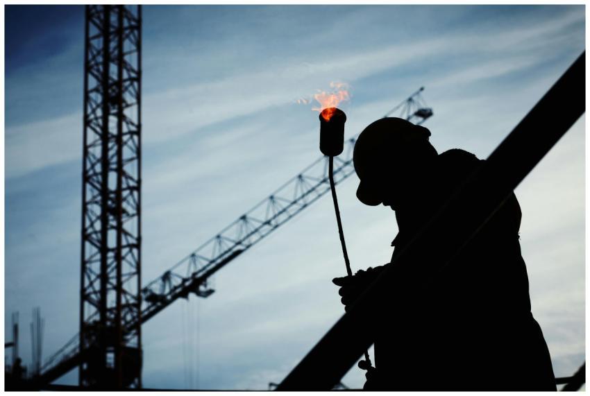 Silhouette of a construction worker using a blowto