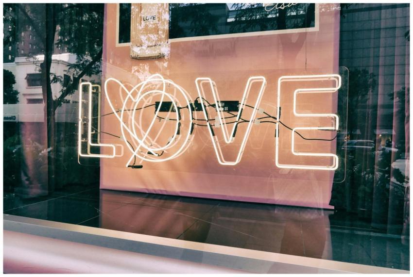 Neon 'LOVE' sign in a modern urban window display
