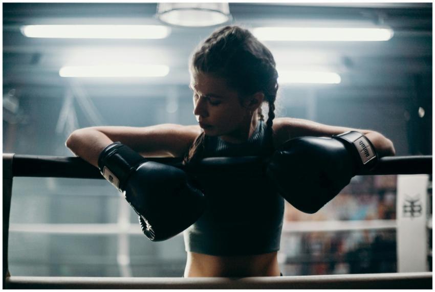 Determined female boxer in training breaks between