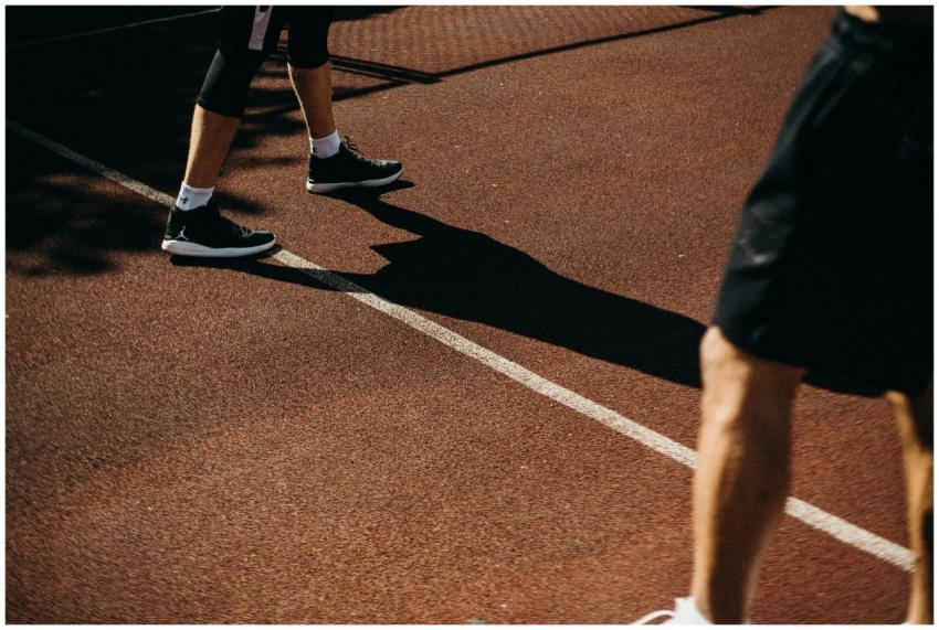 Close-up of athletes' legs on outdoor sports court