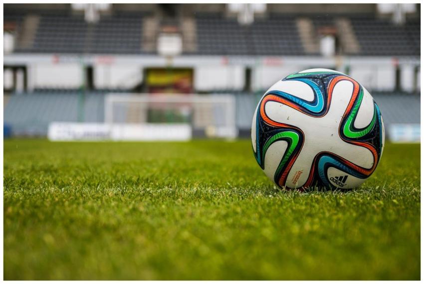 Vibrant soccer ball on a lush green field in an em
