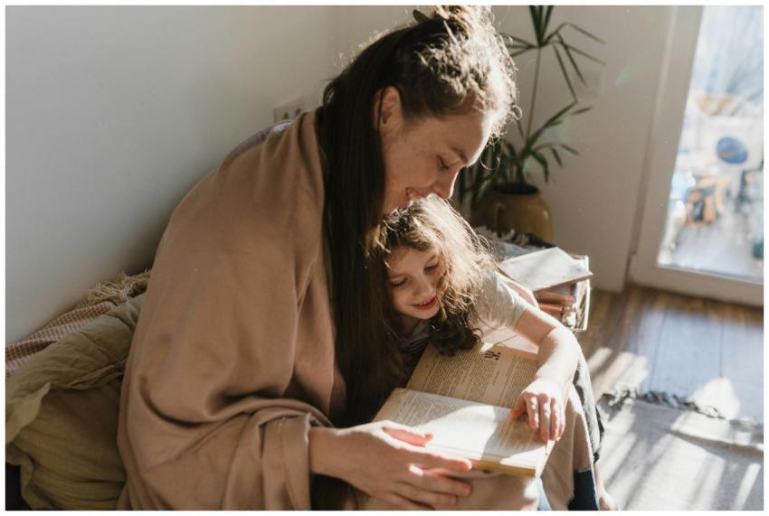 A warm moment of a mother and daughter reading a b