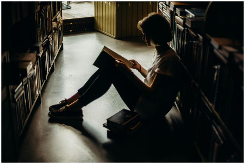 A young woman engrossed in a book, sitting on the