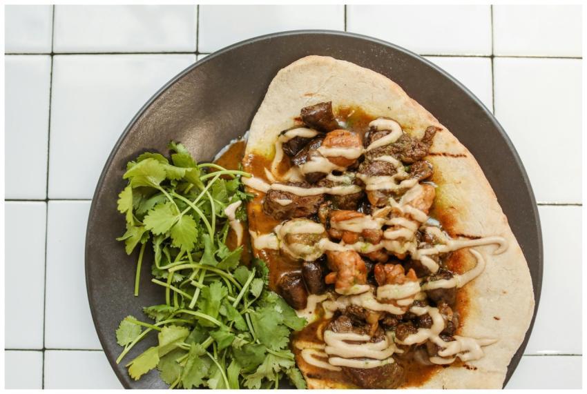 Close-up of savory curry served on naan with fresh