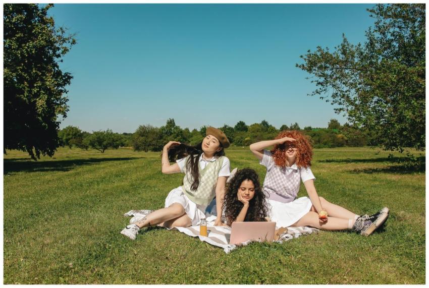 Three young women enjoying a sunny day in a field,