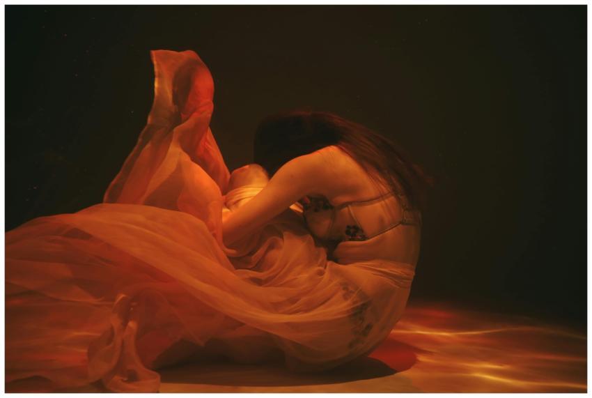 Artistic underwater photo of a woman in flowing dr