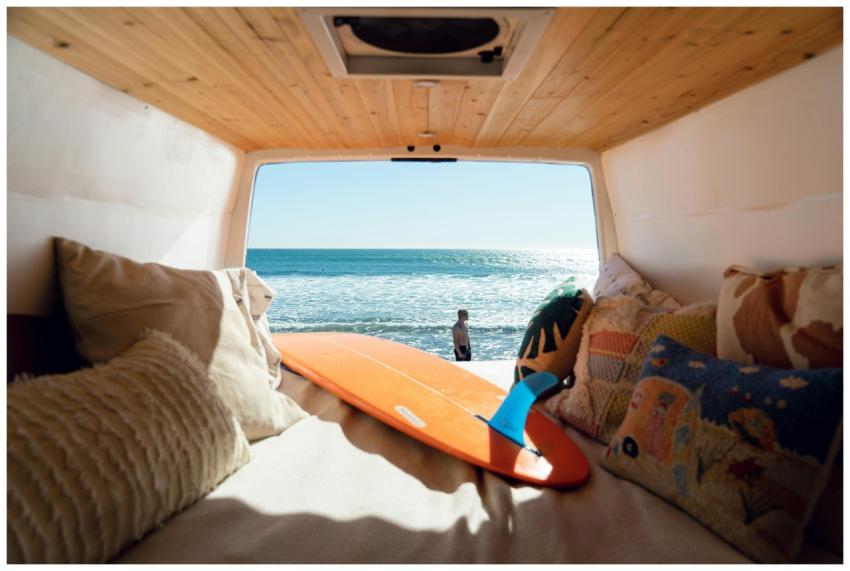 View of the ocean from a cozy van interior with su