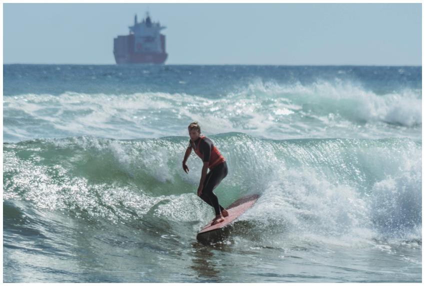 A surfer balances expertly on ocean waves with a l