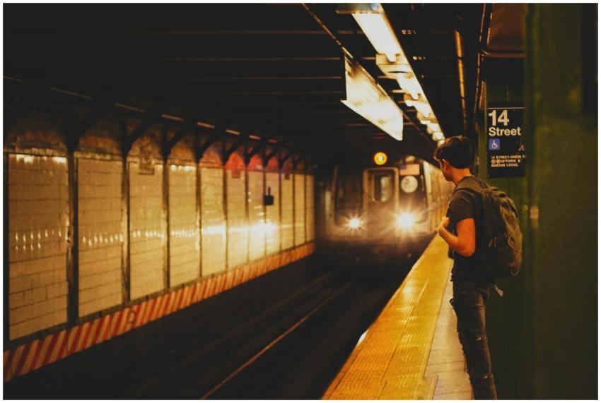 A lone man stands at 14th Street subway platform,