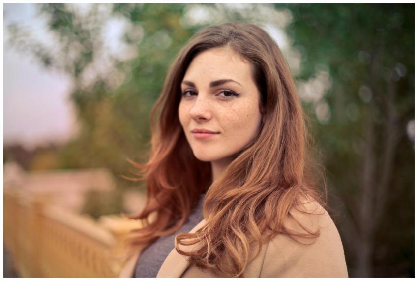A young woman with long hair smiles confidently fo