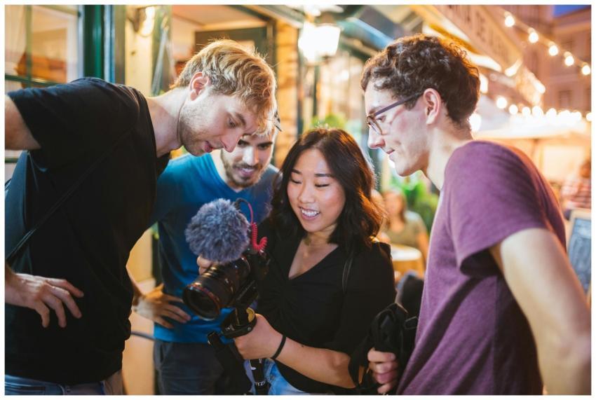 Group of friends reviewing footage on a camera dur