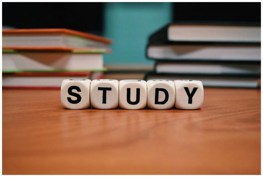 Close-up of study blocks and stacked books on a wo