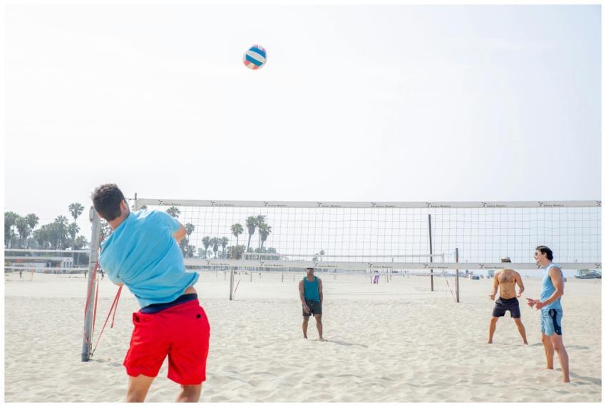 Men playing a vibrant game of beach volleyball on