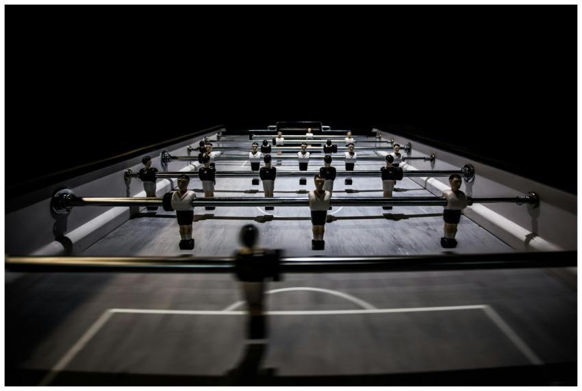 A close-up view of a foosball table under dramatic