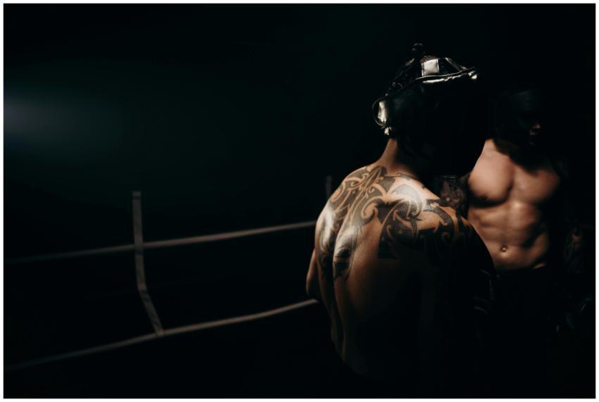 Intense boxing match capturing muscular, tattooed