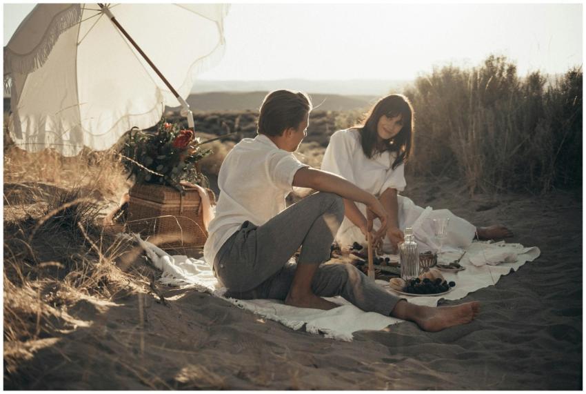 Young loving couple having romantic picnic sitting
