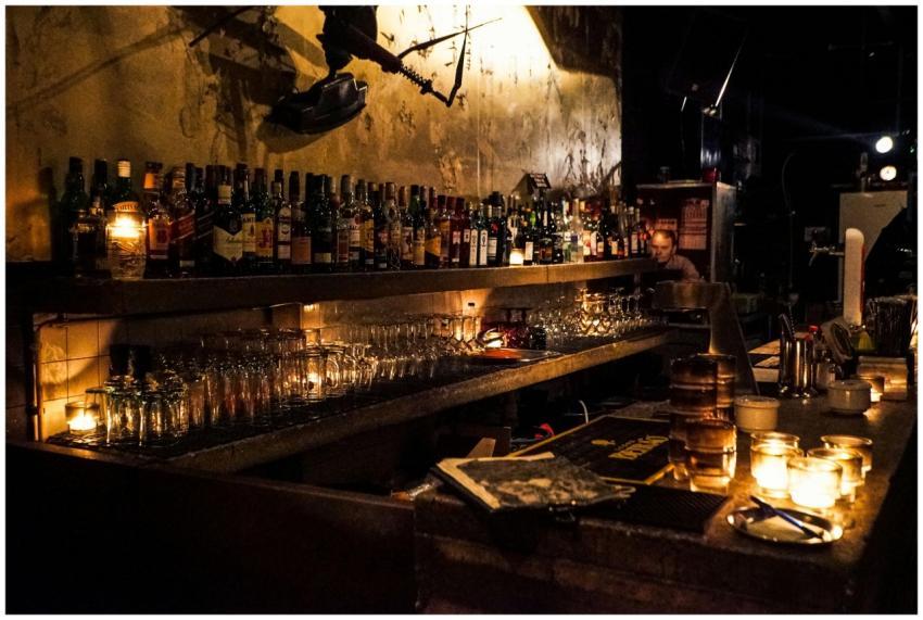 A cozy bar setup with whiskey bottles and warm can