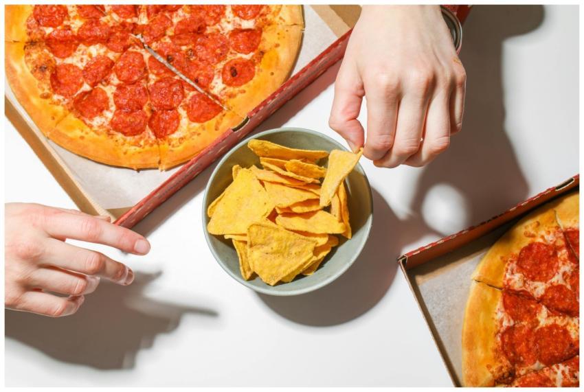 Close-up of pepperoni pizza boxes with a bowl of n
