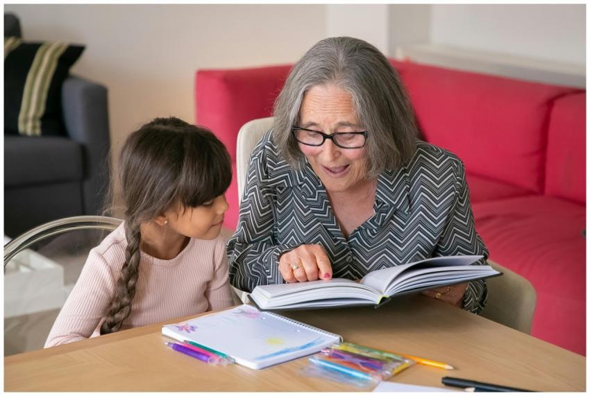A joyful grandmother reading a book with her grand
