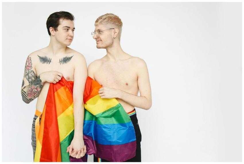 A joyful LGBTQ couple holding a rainbow flag, expr