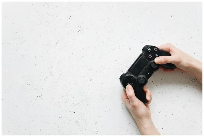 Close-up of hands holding a black game controller