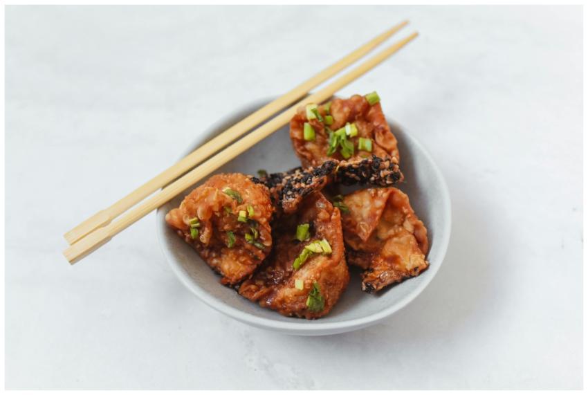Crispy fried dumplings on a plate with chopsticks,