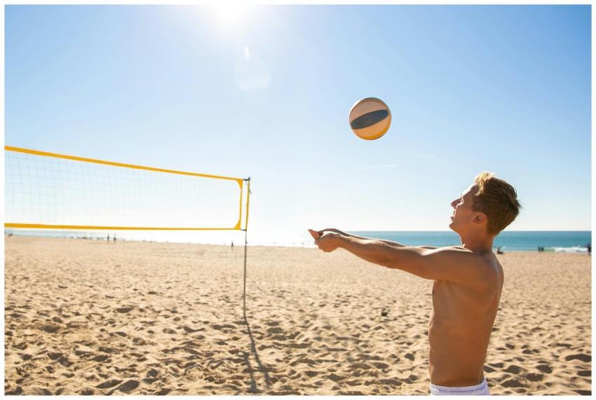 Young man playing beach volleyball on a sunny day,