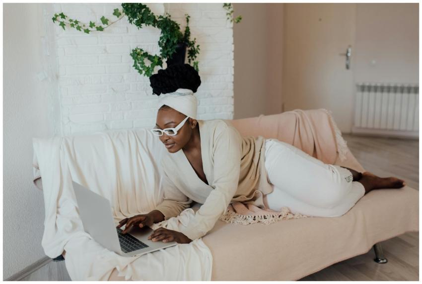 Woman in glasses working from home on a cozy couch