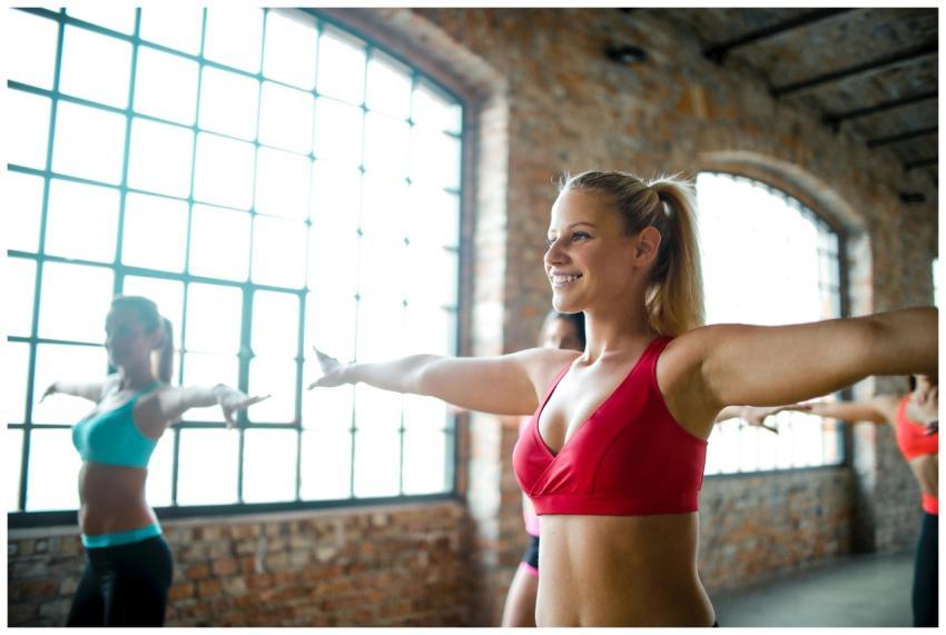 Women practicing fitness routines in a sunlit indu