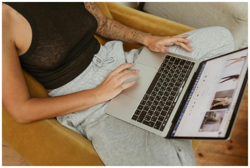 A woman browsing online stores on a laptop while s