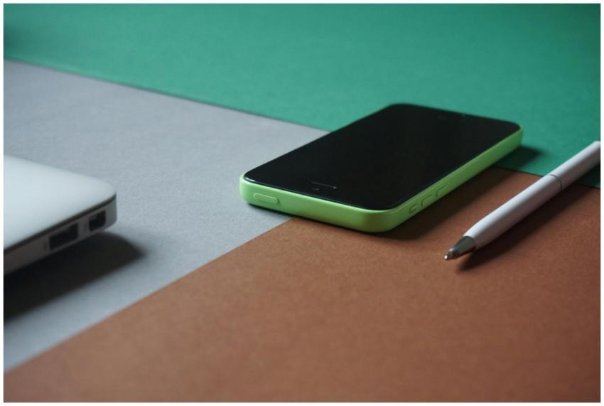 A minimalist workspace featuring a green smartphon