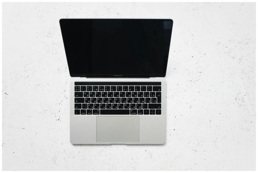 A sleek open laptop placed on a white marble surfa