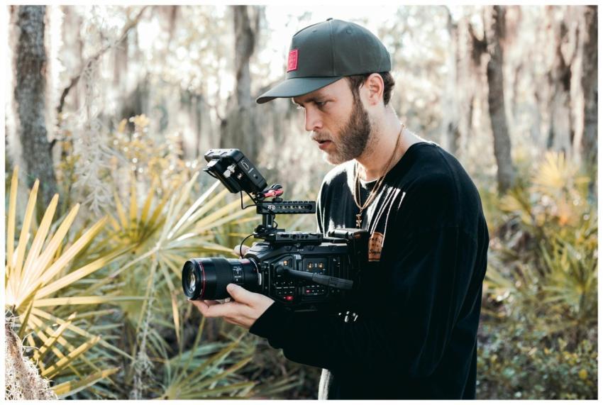 A filmmaker shooting a video in a forest using pro