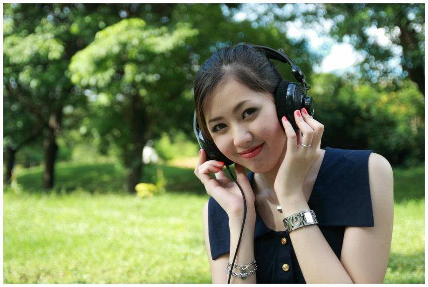 Smiling young woman listening to music with headph