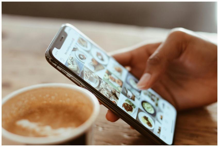 Hand browsing social media photos on a smartphone