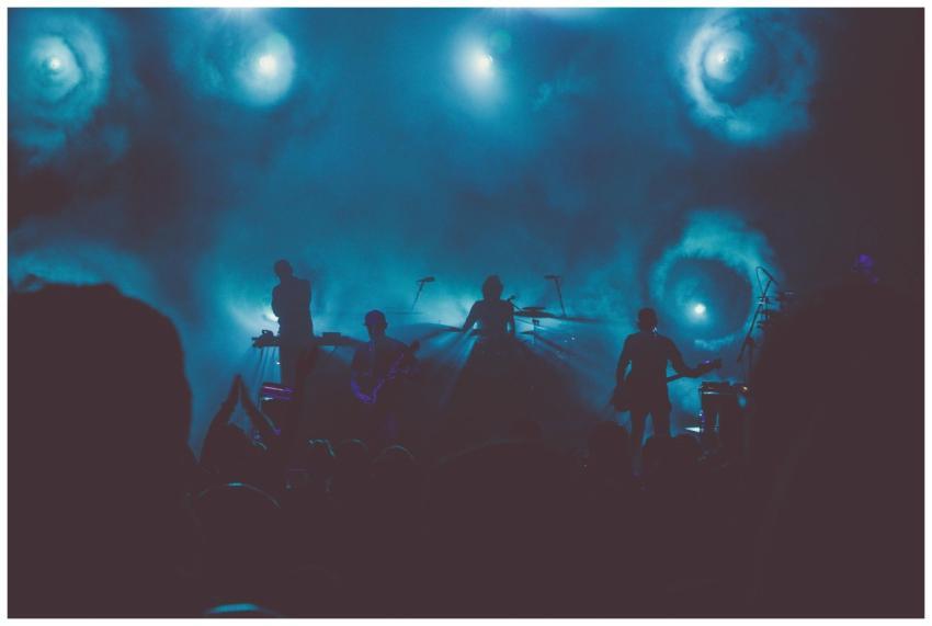 Silhouetted band performing on a smoke-filled stag