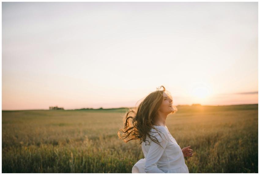 A cheerful woman enjoying a beautiful sunset in a