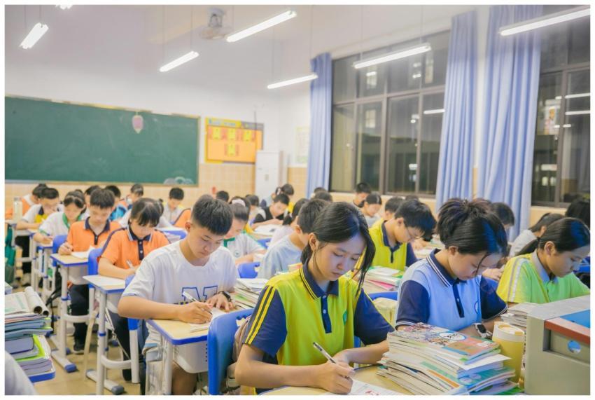 A group of students writing in a classroom during