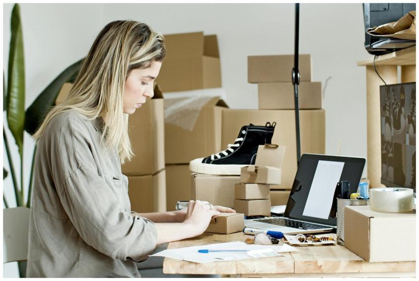 A woman packing boxes for her online store, surrou