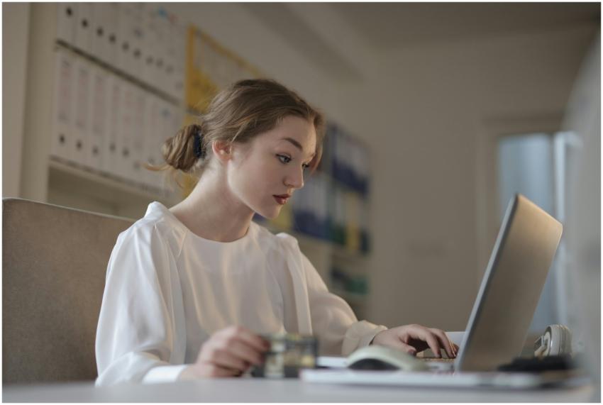Focused young woman working remotely on a laptop i