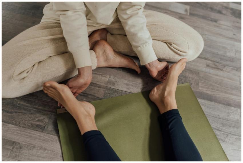 Two individuals engaged in a yoga session on a woo
