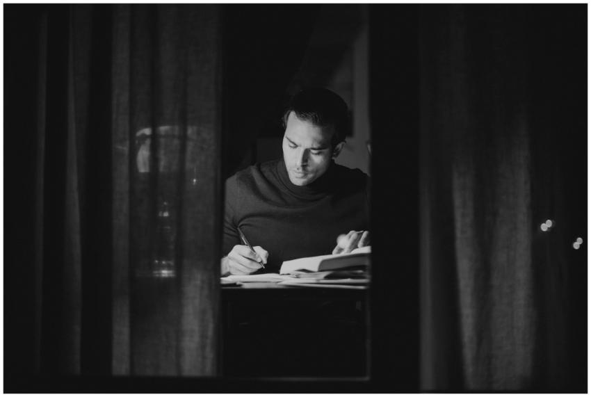 A man deeply focused on studying at night, capture
