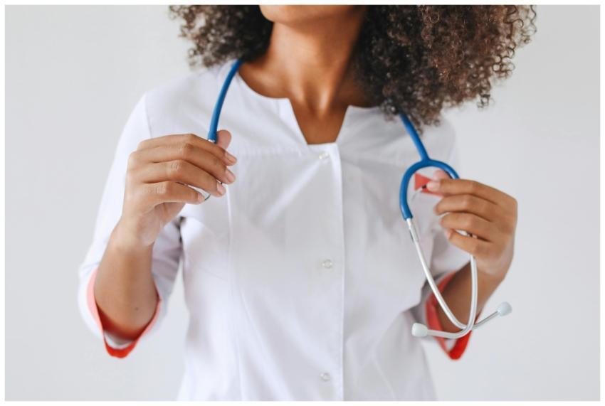 A female doctor holds a stethoscope, focusing on h