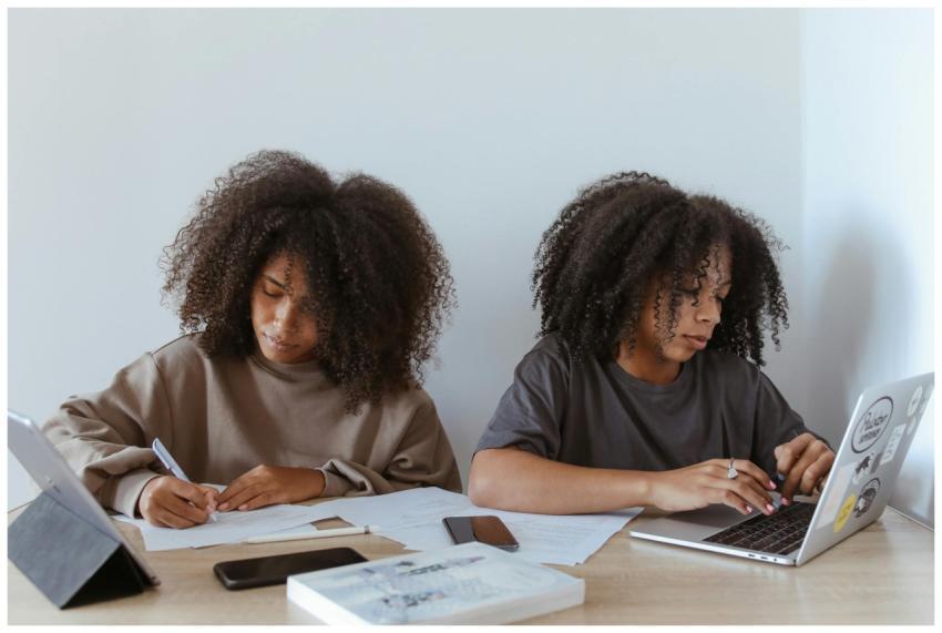 Two young women with curly hair studying together