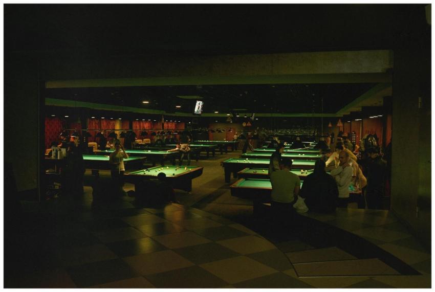 A bustling billiards hall filled with people enjoy