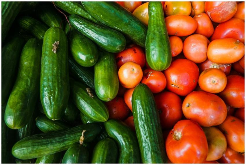 A vibrant display of juicy cucumbers and ripe toma