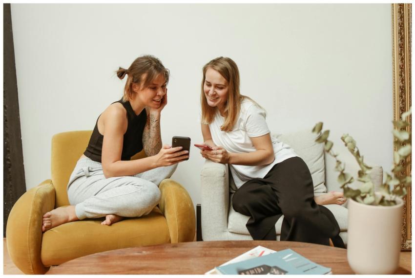 Two women enjoy a casual conversation indoors whil