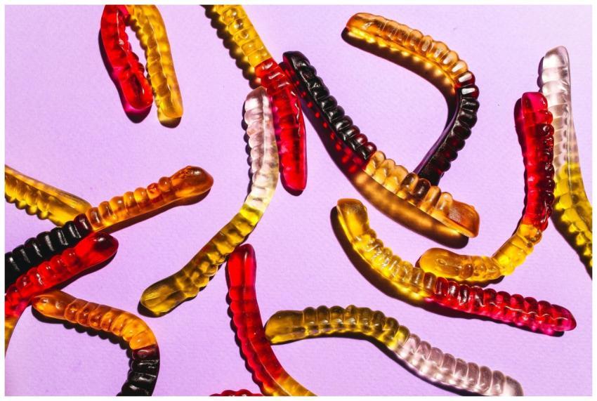 Close-up of colorful gummy worms scattered on a vi