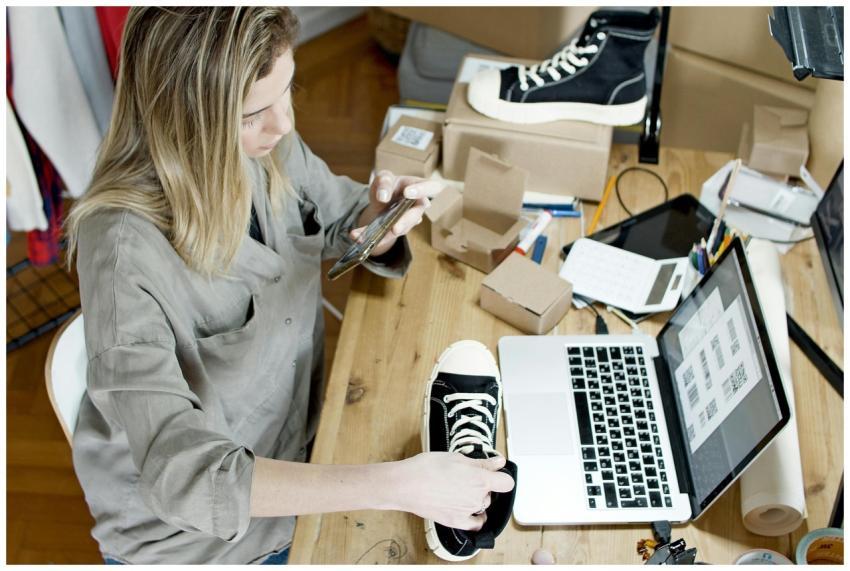 Woman photographing shoes for online sale in home
