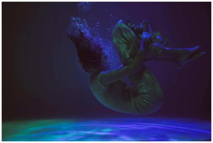 Artistic underwater photo of a person floating gra